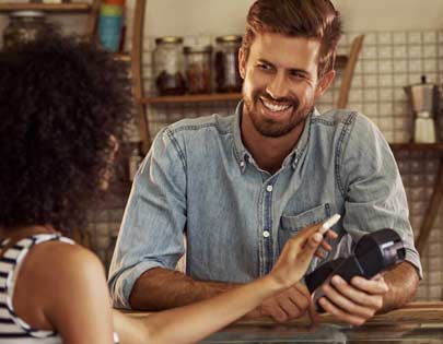 small business owner using pos terminal to accept mobile credit card payment
