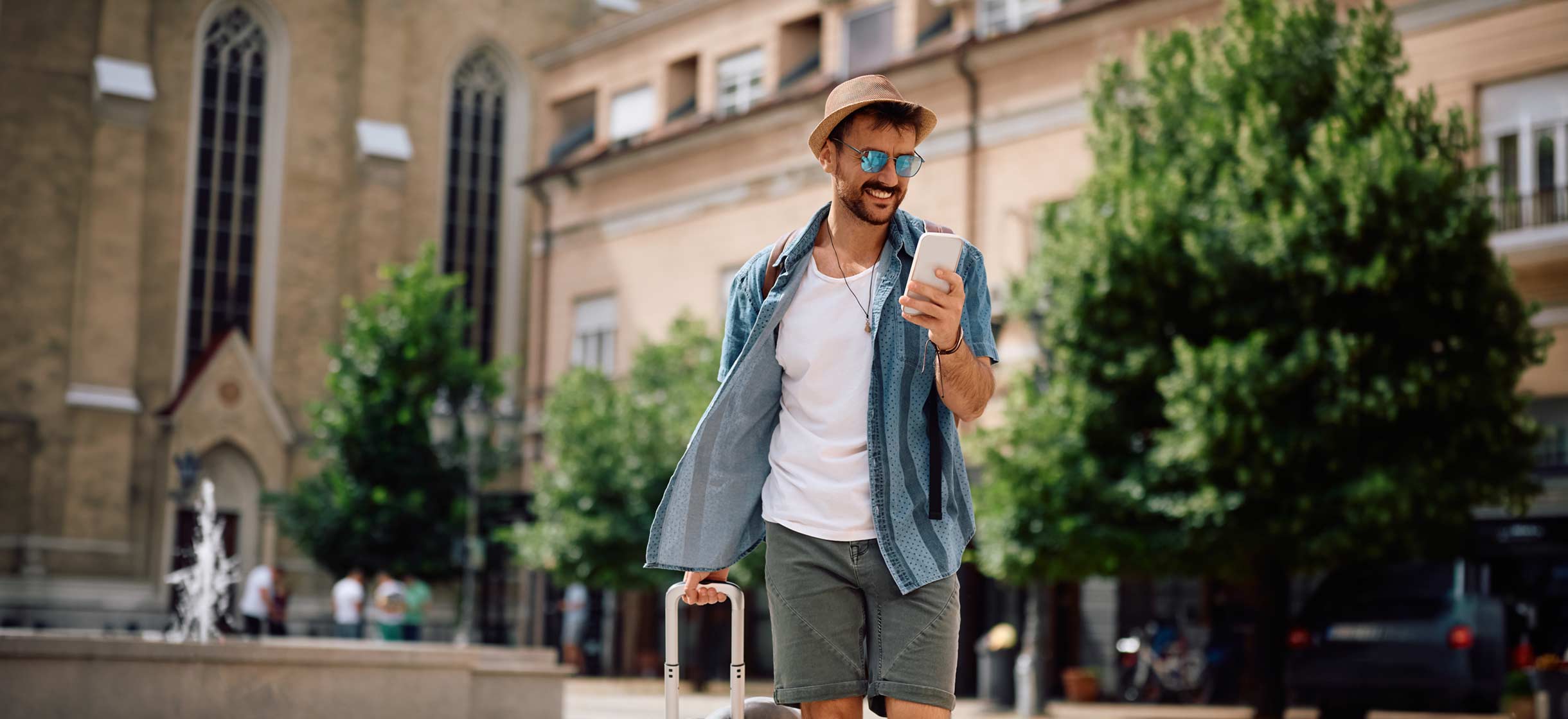 A man traveling and using debit card controls on his mobile banking app